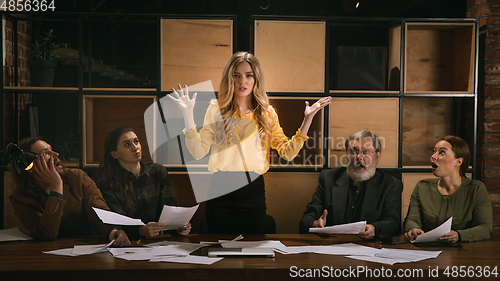 Image of Young colleagues working together in a office styled like classical artworks. Look busy, attented, cheerful, successful. Concept of business, office, finance.