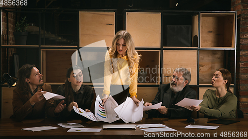 Image of Young colleagues working together in a office styled like classical artworks. Look busy, attented, cheerful, successful. Concept of business, office, finance.