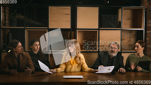 Image of Young colleagues working together in a office styled like classical artworks. Look busy, attented, cheerful, successful. Concept of business, office, finance.