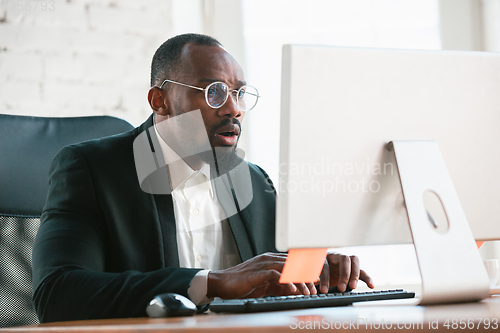 Image of African-american entrepreneur, businessman working concentrated in office
