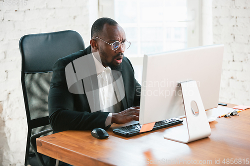 Image of African-american entrepreneur, businessman working concentrated in office