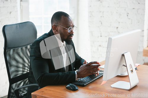 Image of African-american entrepreneur, businessman working concentrated in office