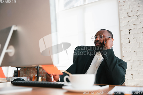 Image of African-american entrepreneur, businessman working concentrated in office