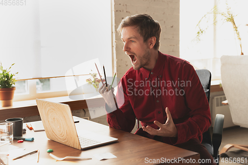 Image of Caucasian entrepreneur, businessman, manager trying to work, looks funny, lazy and spending time