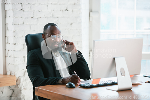 Image of African-american entrepreneur, businessman working concentrated in office