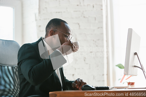 Image of African-american entrepreneur, businessman working concentrated in office