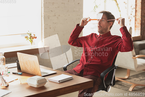 Image of Caucasian entrepreneur, businessman, manager trying to work, looks funny, lazy and spending time