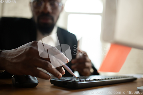 Image of African-american entrepreneur, businessman working concentrated in office