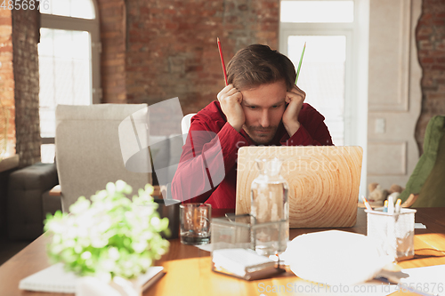 Image of Caucasian entrepreneur, businessman, manager trying to work, looks funny, lazy and spending time