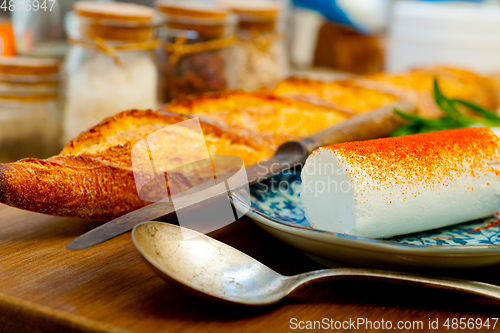 Image of French cheese and fresh  baguette on a wood cutter