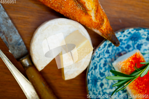 Image of French cheese and fresh  baguette on a wood cutter