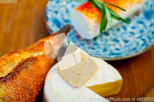 Image of French cheese and fresh  baguette on a wood cutter