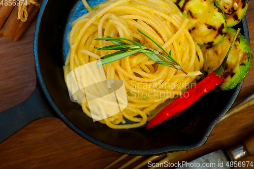 Image of italian spaghetti pasta with zucchini sauce on iron skillet