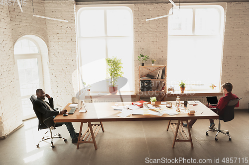 Image of Caucasian entrepreneur, businessman, manager trying to work, looks funny, lazy and spending time