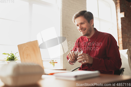 Image of Caucasian entrepreneur, businessman, manager trying to work, looks funny, lazy and spending time