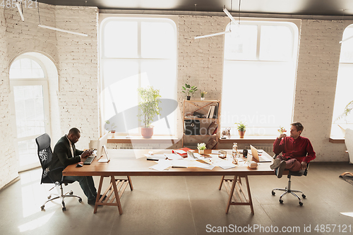 Image of Caucasian entrepreneur, businessman, manager trying to work, looks funny, lazy and spending time