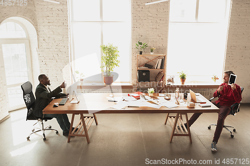 Image of Caucasian entrepreneur, businessman, manager trying to work, looks funny, lazy and spending time