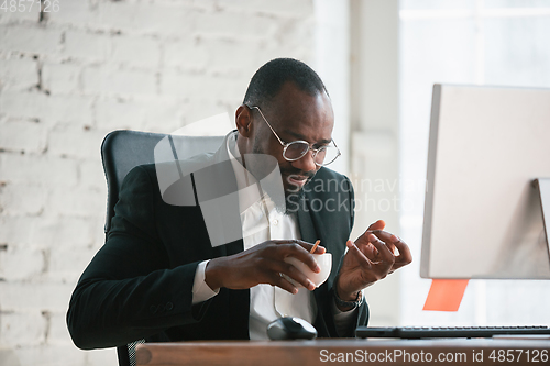 Image of African-american entrepreneur, businessman working concentrated in office