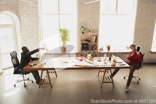 Image of Caucasian entrepreneur, businessman, manager trying to work, looks funny, lazy and spending time