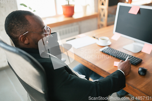 Image of African-american entrepreneur, businessman working concentrated in office