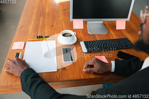 Image of African-american entrepreneur, businessman working concentrated in office