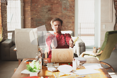 Image of Caucasian entrepreneur, businessman, manager trying to work, looks funny, lazy and spending time