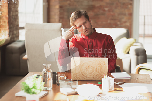 Image of Caucasian entrepreneur, businessman, manager trying to work, looks funny, lazy and spending time