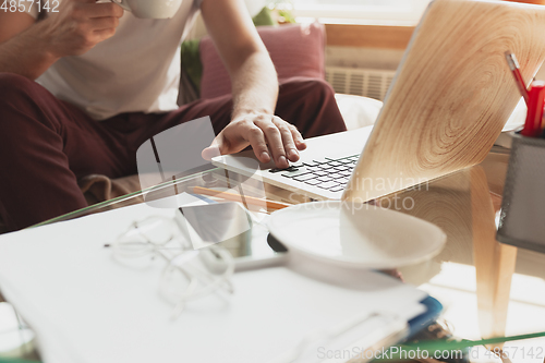 Image of Young man studying at home during online courses for financist, economist, managers