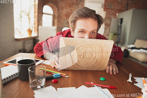 Image of Caucasian entrepreneur, businessman, manager trying to work, looks funny, lazy and spending time