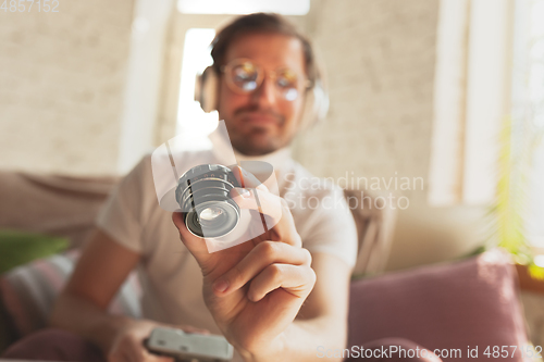 Image of Young man studying at home during online courses for photographer, studio assistant