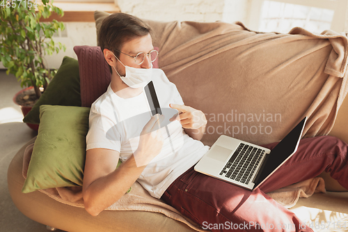 Image of Young man studying at home during online courses for disinfector, nurse, medical services