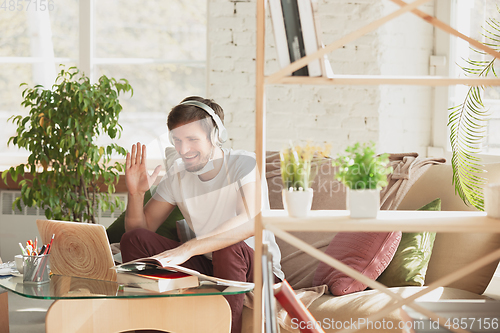 Image of Young man studying at home during online courses for marketer, architect, translator