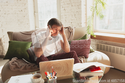 Image of Young man studying at home during online courses for designers, SMM, SEO, analytics