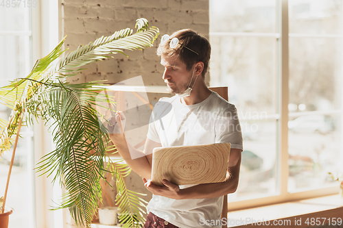 Image of Young man studying at home during online courses for gardener, biologist, florist