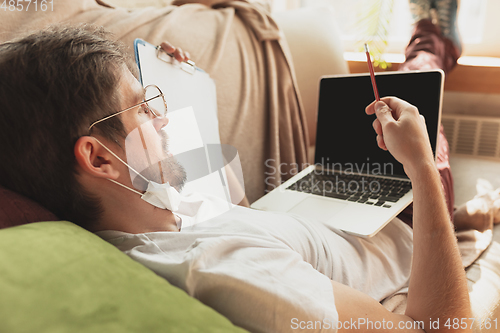 Image of Young man studying at home during online courses for journalist, critics, writers