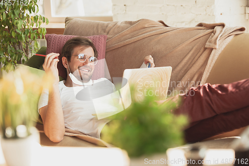 Image of Young man studying at home during online courses for journalist, critics, writers