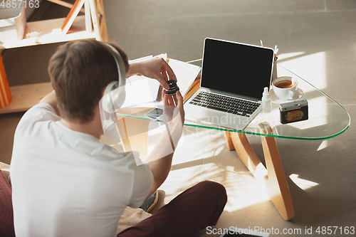 Image of Young man studying at home during online courses for photographer, studio assistant