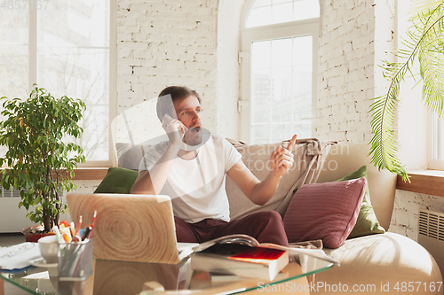 Image of Young man studying at home during online courses for designers, SMM, SEO, analytics