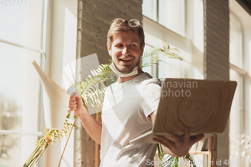 Image of Young man studying at home during online courses for gardener, biologist, florist