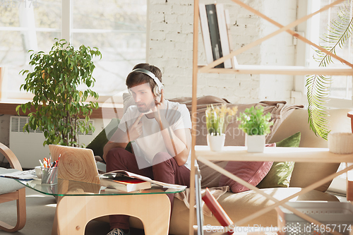 Image of Young man studying at home during online courses for marketer, architect, translator