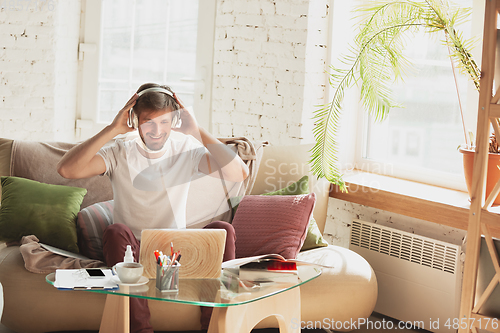 Image of Young man studying at home during online courses for marketer, architect, translator