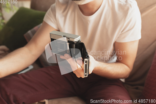 Image of Young man studying at home during online courses for photographer, studio assistant