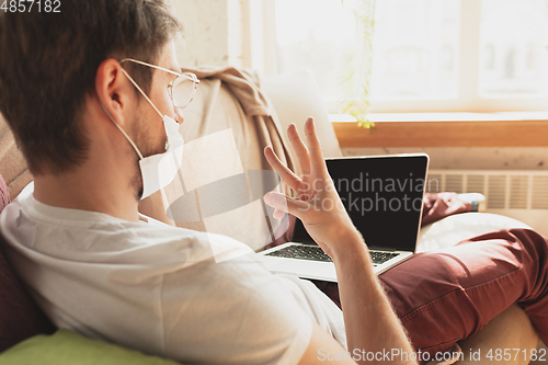 Image of Young man studying at home during online courses for disinfector, nurse, medical services