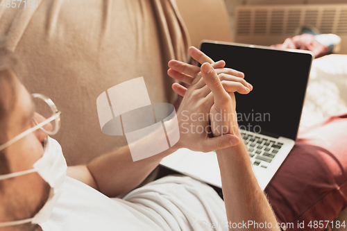 Image of Young man studying at home during online courses for disinfector, nurse, medical services