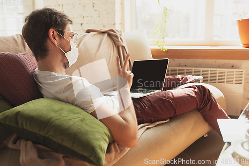 Image of Young man studying at home during online courses for disinfector, nurse, medical services