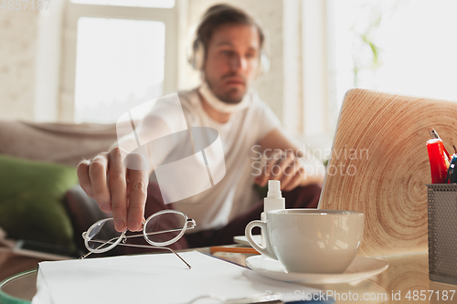 Image of Young man studying at home during online courses for programmer, bug-tester, consulter