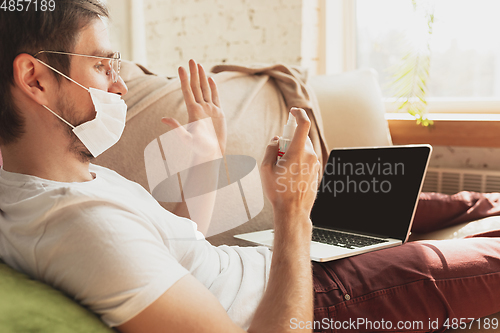 Image of Young man studying at home during online courses for disinfector, nurse, medical services