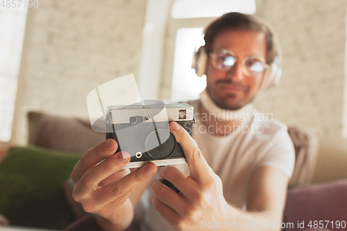 Image of Young man studying at home during online courses for photographer, studio assistant