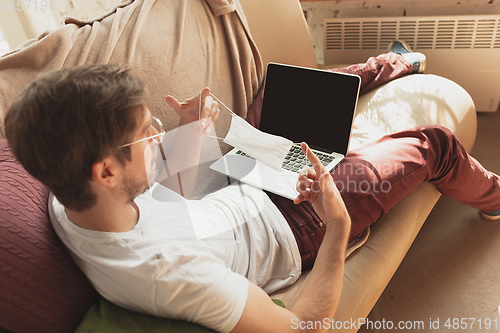 Image of Young man studying at home during online courses for disinfector, nurse, medical services