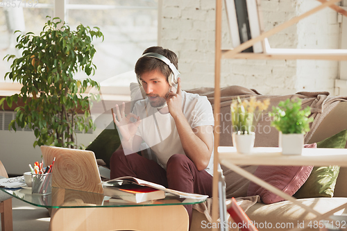Image of Young man studying at home during online courses for programmer, bug-tester, consulter